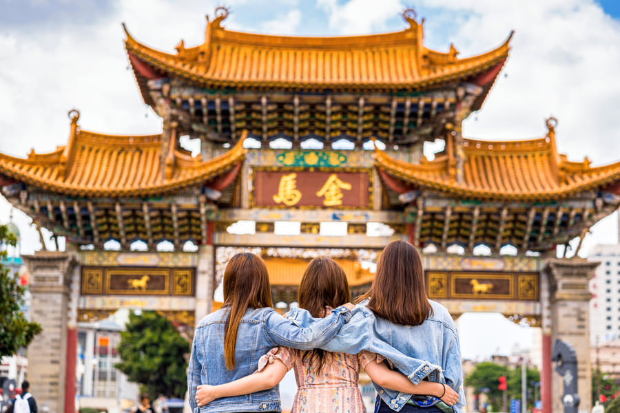 tres mujeres de pie de espaldas mientras miran una templo chino